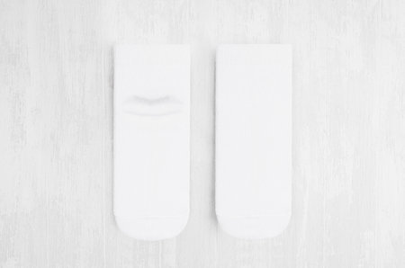 Pair blank white medium socks flat lay on white wood board, front view, backside - mock up for...