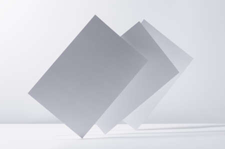 Abstract white gray minimalist background with flying papers in light with shadow as blank copy...