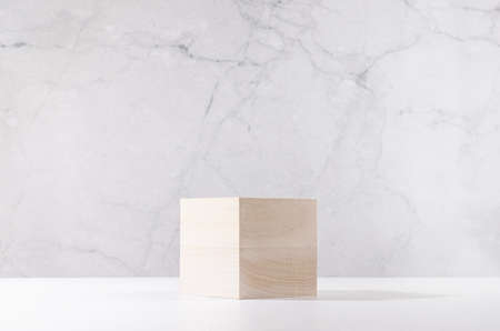 Elegant podium of beige wooden cube on white board and gray marble wall for product display. Simple...