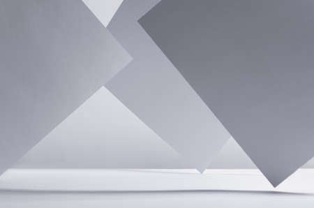Modern simple geometric white gray abstract background with asymmetric standing papers with perspective, light and shadow, stripes as frame, copy space.の写真素材