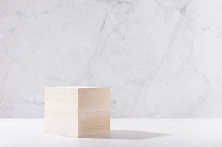 Minimal modern showcase with wooden cube podium on white board and gray marble wall for cosmetics...