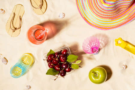 Tropical beach vacation background with beach games and toys - fresh cold pink drink with straw,...