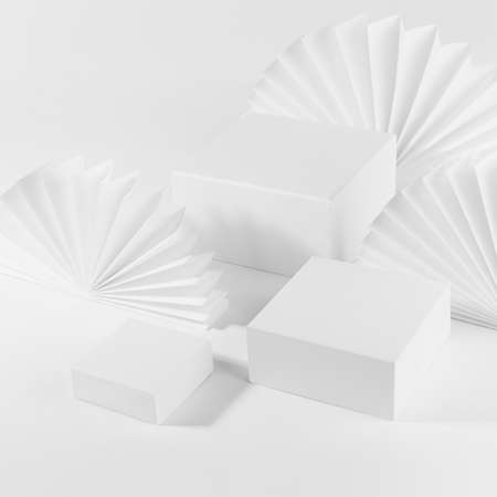 White abstract stage mockup with three different size square podiums for presentation cosmetic product, goods on table with simple geometric decor - asian paper fans, top view, corner, 3d, square.の写真素材