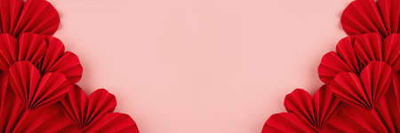 Valentines day banner - beautiful red paper ribbed hearts in simple origami style on pastel pink color as sideways border, frame, copy space, top view.の写真素材