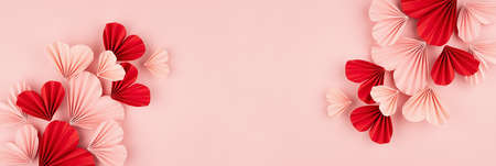 Holiday Valentine day banner for website with flow of flying pink and red paper folded ribbed hearts...
