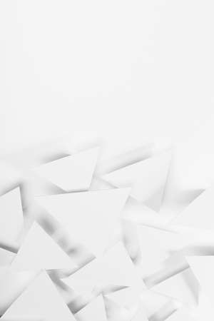 White paper triangles as abstract geometric texture in bright light with soft light shadows, top view, vertical. Simple tender purity dynamic mosaic background in minimal style.の写真素材