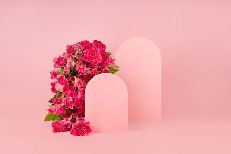 Fresh pink roses as arch, empty rounded doors as two podiums on abstract pink scene mockup for presentation cosmetic products or goods, copy space. Romantic summer template for advertising, design.の写真素材