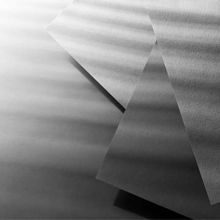 Graphite gray abstract textured stepped geometric background with corners of fly rectangle paper...
