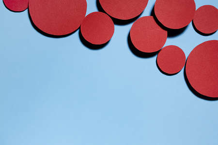 Colorful abstract background with red textured circles as decorative swarm, border with copy space for text on blue background in cute funny simple minimal style.の写真素材