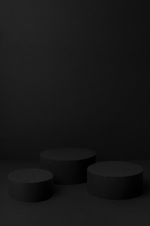 Abstract black stage with three cylinder podiums mockup for presentation cosmetic products, goods, advertising, design, text with soft gradient, in trendy exquisite simple style, vertical, copy space.の写真素材