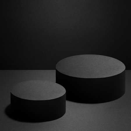 Abstract two black round podiums with light of spotlight for cosmetic products, mockup on black background. Black stage template for showing products, advertising, design, poster, text, card.の写真素材