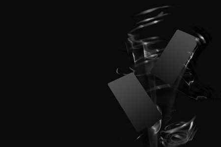 Two black blank bank cards or greeting card mockup for branding text or advertising, design flying in energy flow of white light with spiral trails, swirl, haze as bang on black monochrome background.の写真素材