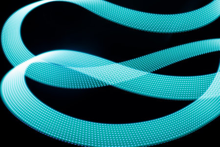 Turquoise blue glowing neon wave of light as curls or swirl with dotted stripes on black background,...