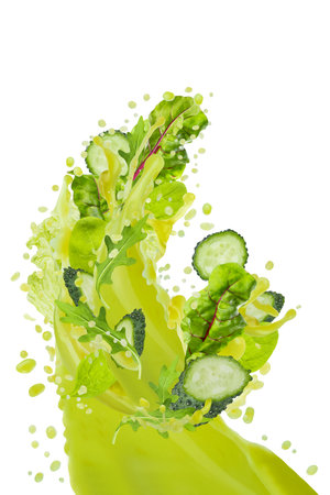 Stream of fresh green vegetable juice flow pour in air with flying green leafy greens, cucumber slices, bursting splashing, isolated. Healthy drink for antioxidant diet, fitness menu, detox cuisine.の写真素材