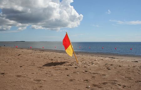 Lifeguard on duty flag on beachの写真素材