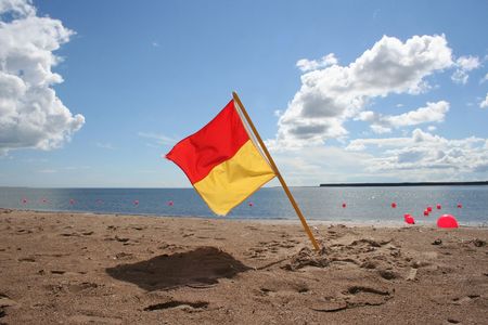Lifeguard on duty flag on beachの写真素材