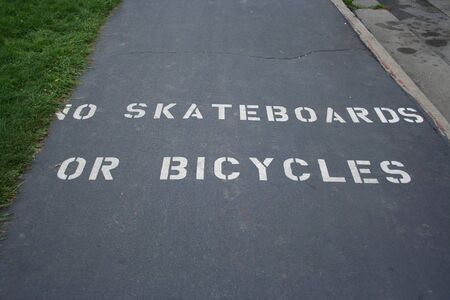 no skateboards or bicycles sign painted on footpathの写真素材