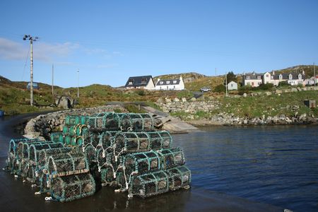 lobster pots stacked in piles beside sea shoreの写真素材