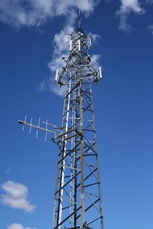 Looking up at communication tower and blue sky