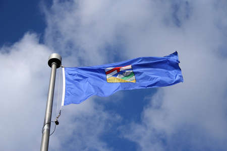 Flag of Alberta against sky with white cloudsの写真素材
