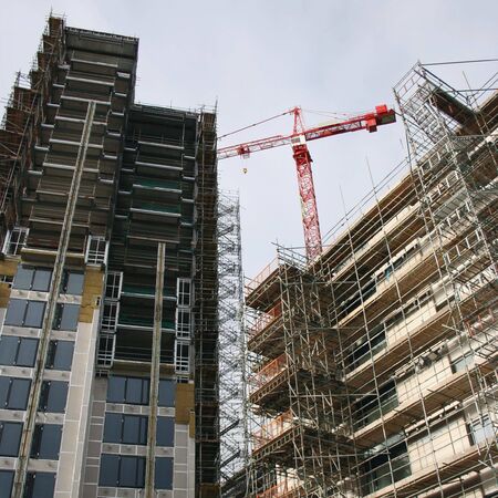 Skyscraper construction site with scaffolding and crane