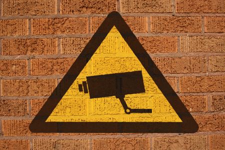 warning CCTV sign painted on brick wall