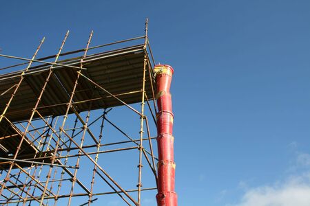 plastic debris chute and scaffolding at construction siteの写真素材