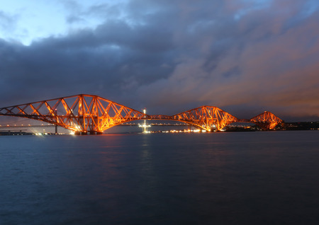 Forth Rail Bridge illuminated at dusk Scotlandの写真素材