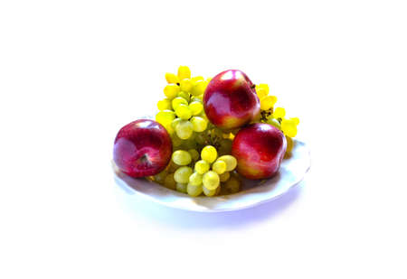 grapes with apples on the plate isolated on white backgroundの写真素材