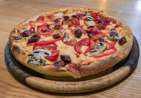 Tasty appetizing pizza with cheese, sausages, mushrooms, papricaの写真素材