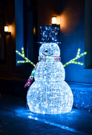 Luminous Christmas Snowman made of blue electric garland in the darkの写真素材