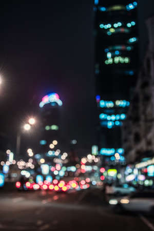 Blurred glowing skyscrapers and cars. Night city street  lights background