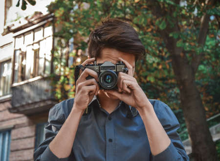 Hipster photographer with retro film photo cameraの写真素材