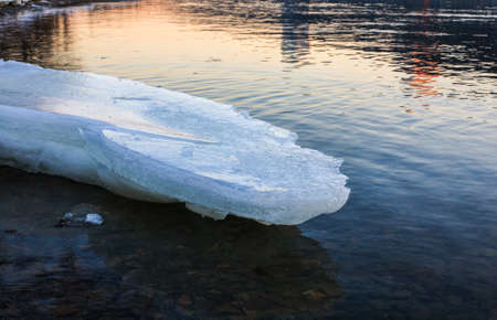 Ice floe melting on the coast at sunset