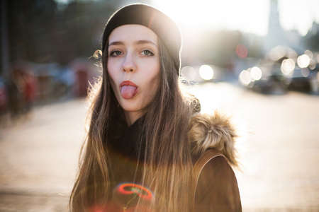 Cheerful positive hipster girl showing tongue looking at cameraの写真素材