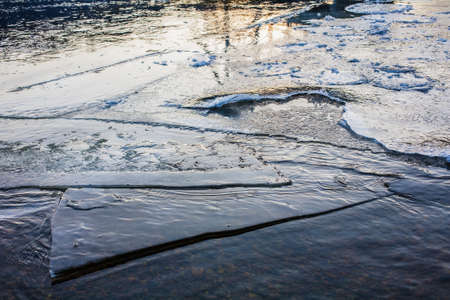 Frozen river surface covered with melting iceの写真素材