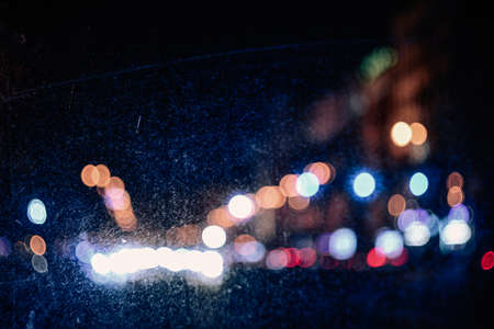 Blurred night city lights through scratched windowの写真素材