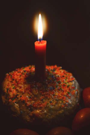 Easter cake with candle and painted eggs in the darkの写真素材