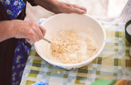 Grandmother preparing batter for pancakesの写真素材