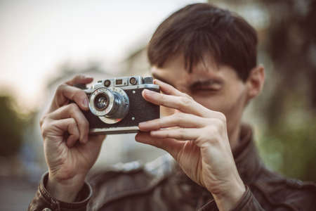 Hipster man taking photo with retro camera