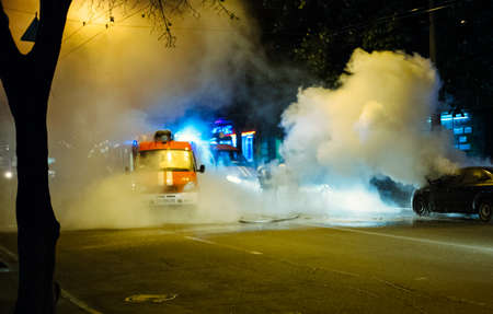 Firemen extinguishing a car fire