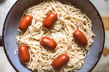 Sausages with pasta in vintage frying panの写真素材