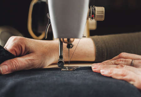 Vintage sewing machine and woman's hands, sewing processの写真素材