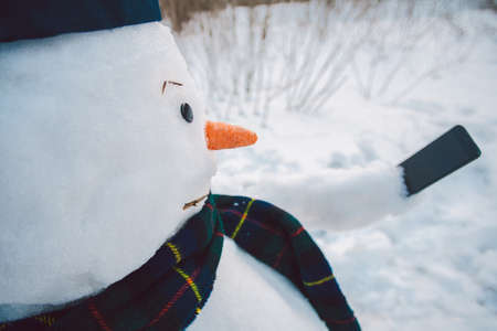 Snowman using smart phoneの写真素材