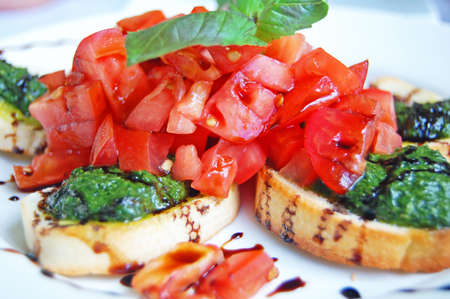 bruschetta topped with chopped tomato and pesto with balsamicの写真素材