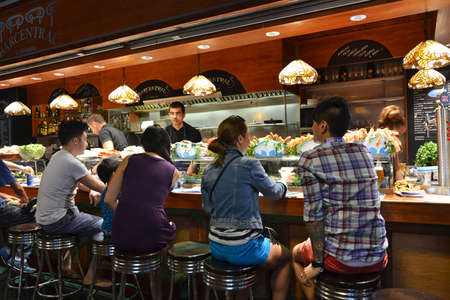 Barcelona - August 21: customers seated at a tapas bar at La Boqueria market in Barcelona, Spain on Augut 21, 2014. The market is one of the oldest in Europe and a popular tourist attraction.のeditorial素材