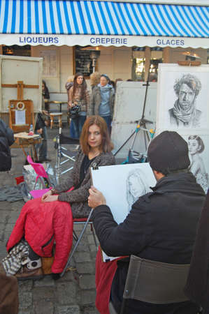 Montmartre, France - October 31, 2012: Place du Tertre in Montmartre, Paris with street artist doing portrait of young woman. The area is a popular tourist attraction in Paris.のeditorial素材
