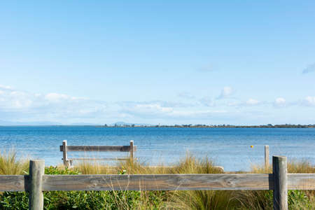 Wooden bench in front of the sea in Australia