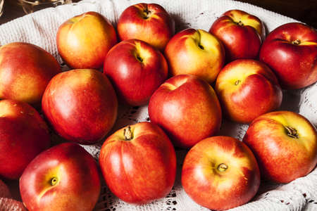 Peaches in a basket with white tableclothの写真素材