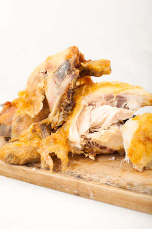 Roast chicken pieces on a wooden cutting boardの写真素材